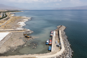 Van Gölü'nde suların çekilmesiyle karaya oturan teknelerin bulunduğu barınak derinleştiriliyor